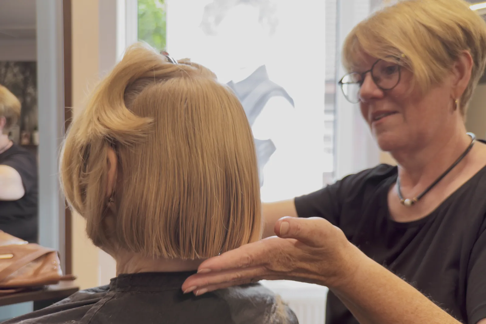 Friseurin berät zur Schnittlänge an einem Bob