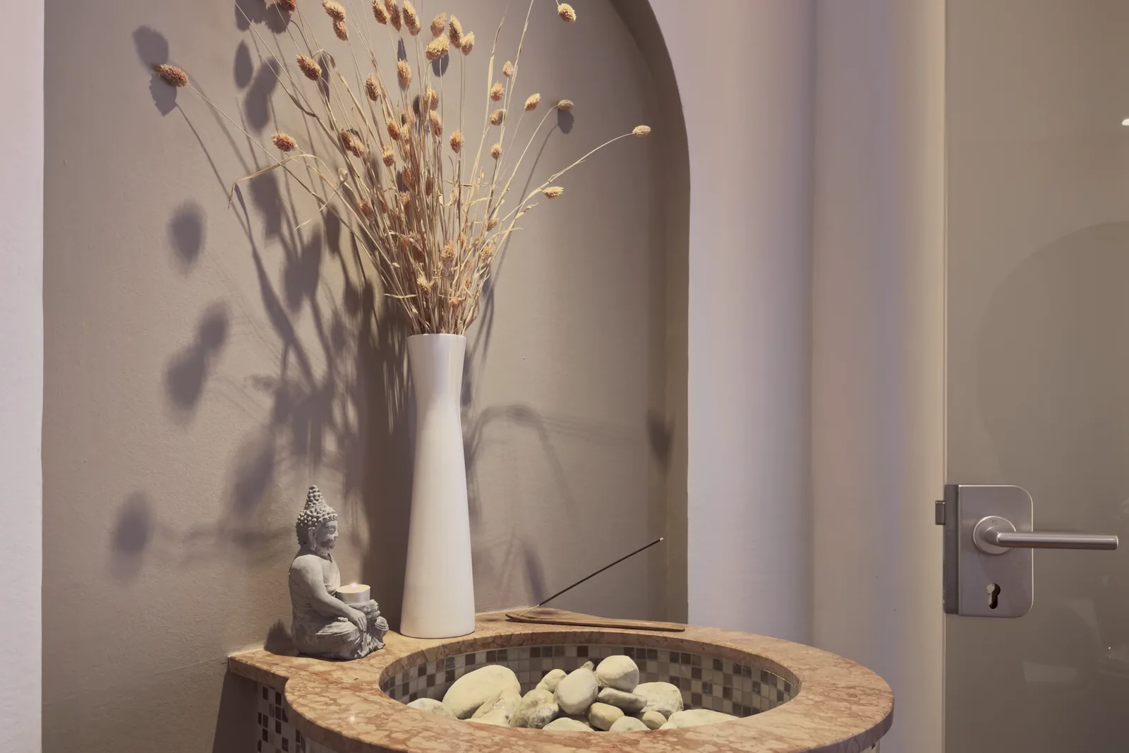 Nische mit Trockengras und Steinbecken im Wellnessbereich