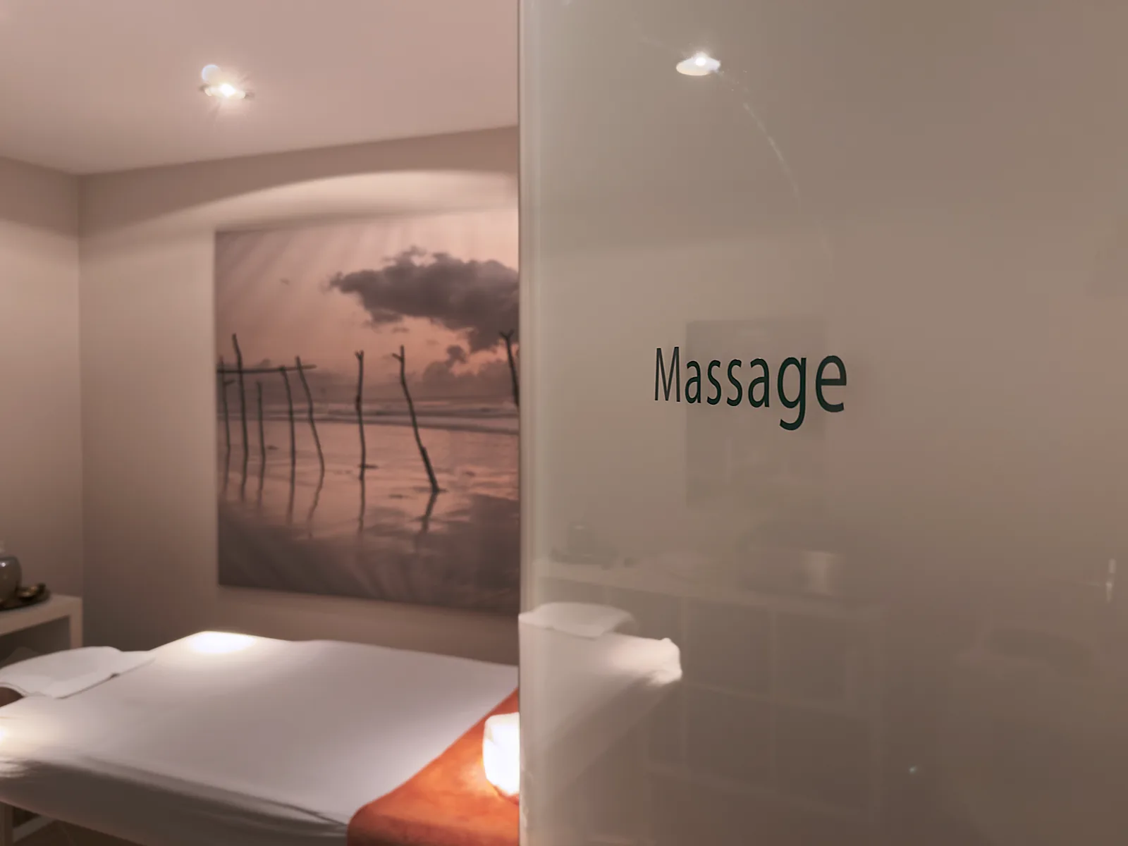Blick durch die Glastür in den Massageraum im Wellnessbereich