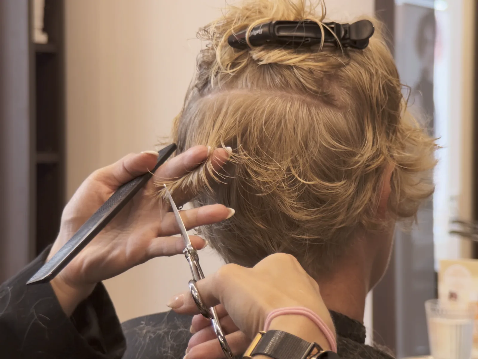 Friseurin schneidet mit Kamm und Schere