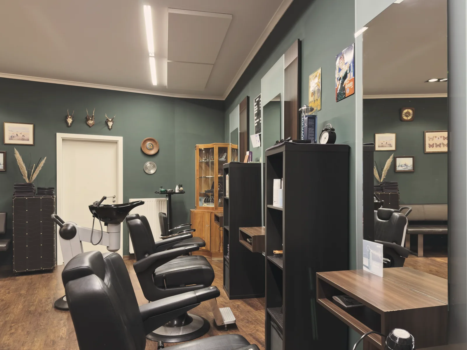 Barber-Bereich mit grüner Wand und Geweihen